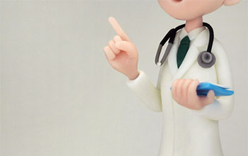 人差し指を立てる医師の人形